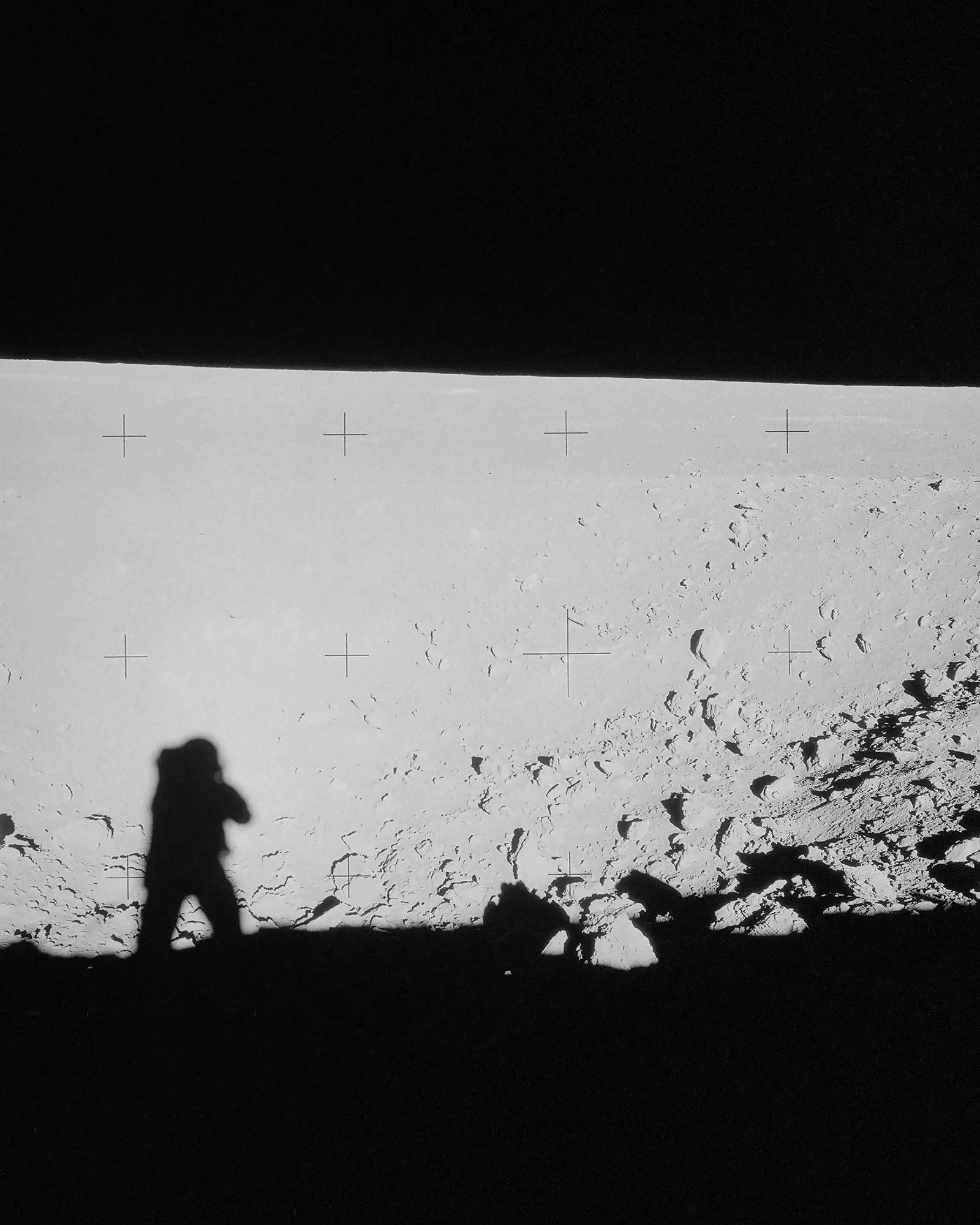 Astronaut standing on the moon beside the lunar module, surrounded by boot prints